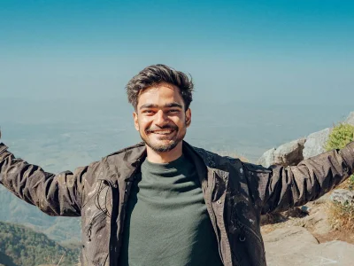 Joyful man on a mountain peak embracing nature