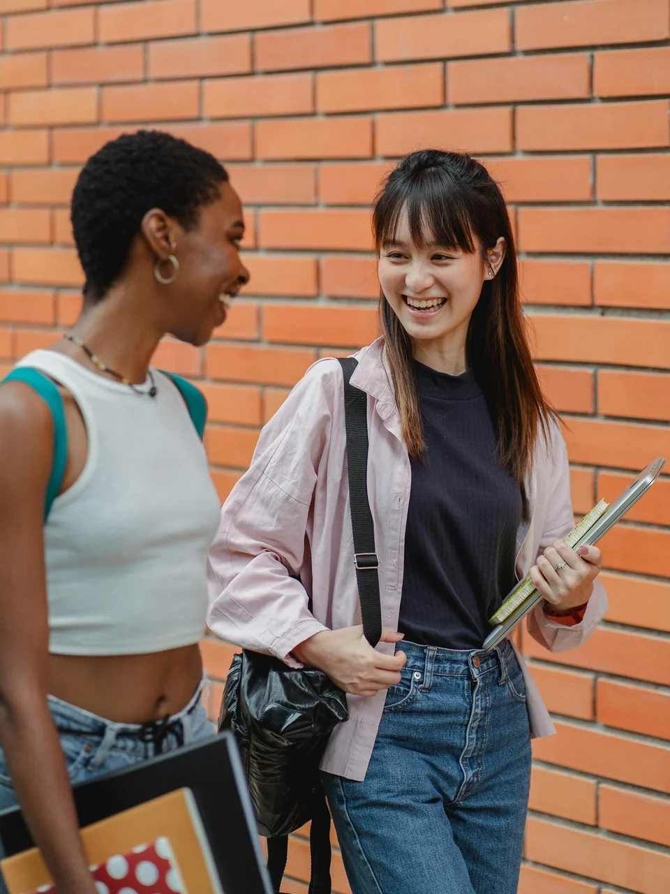 Diverse female students laughing while walking together