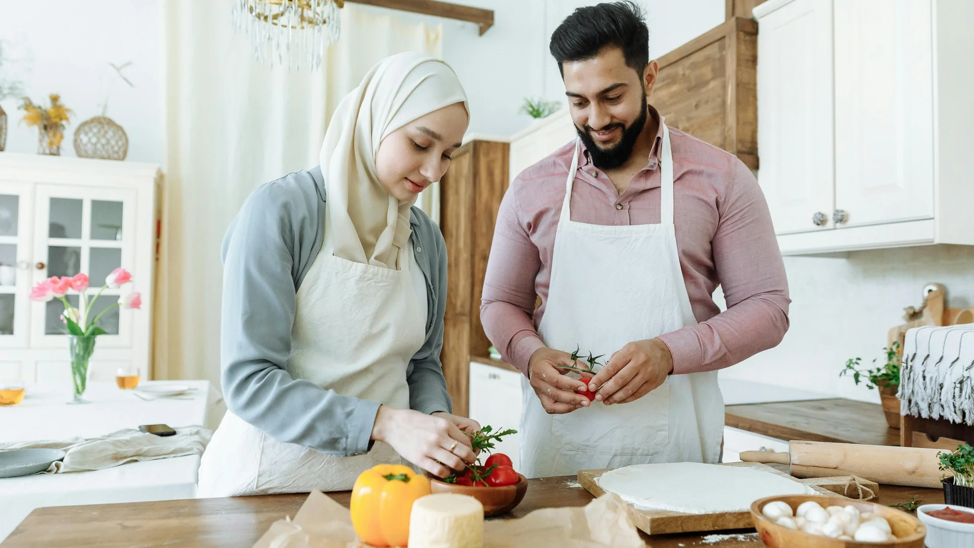 Couple preparing food together in a modern kitchen, sharing a warm moment