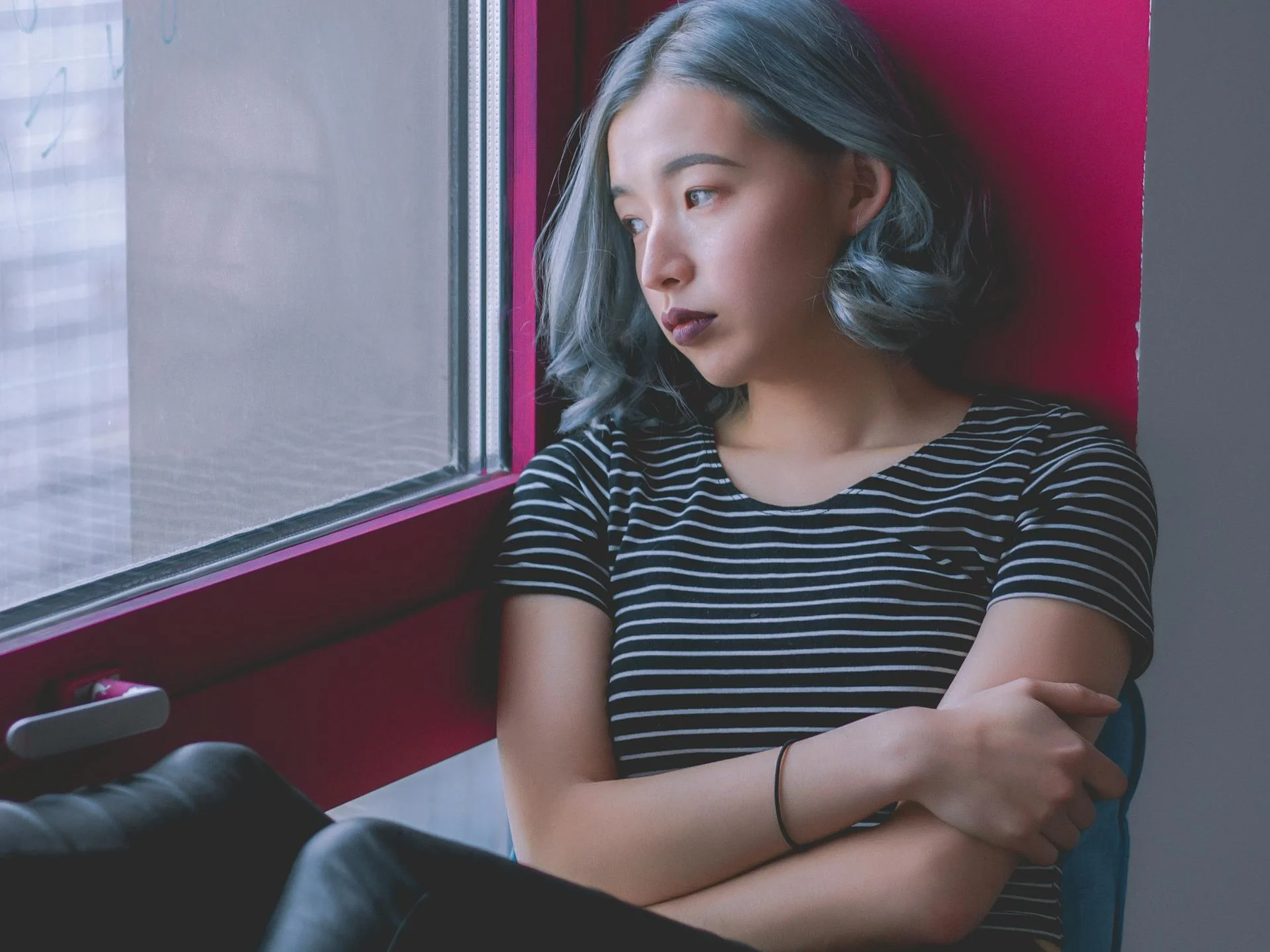 Woman sitting by a window, deep in thought