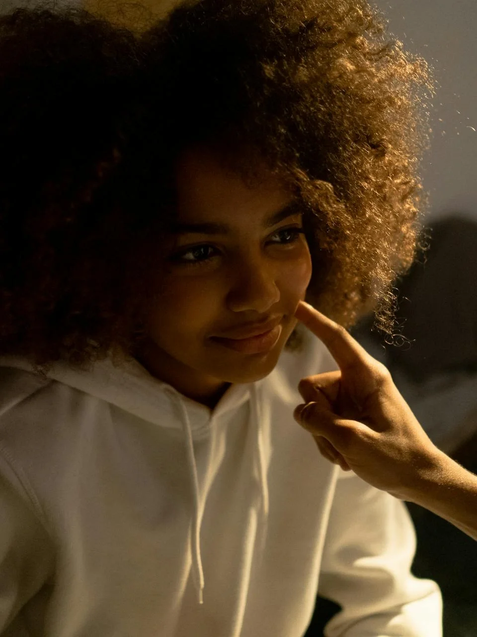Young woman with afro hair in a warm, cozy setting