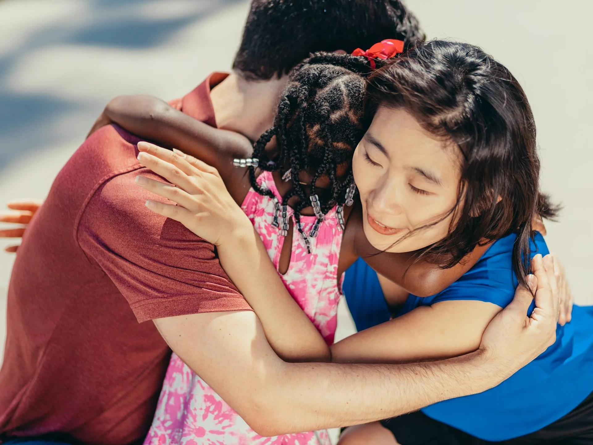 Diverse family sharing a heartfelt group hug outdoors