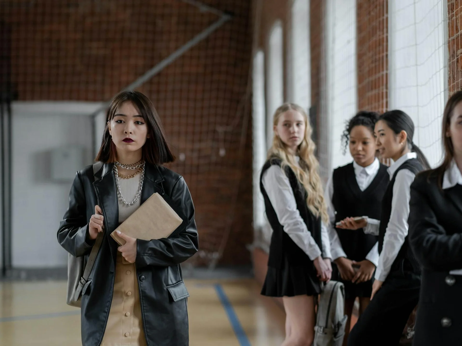 Teenage girls interacting in a school gym, highlighting social dynamics