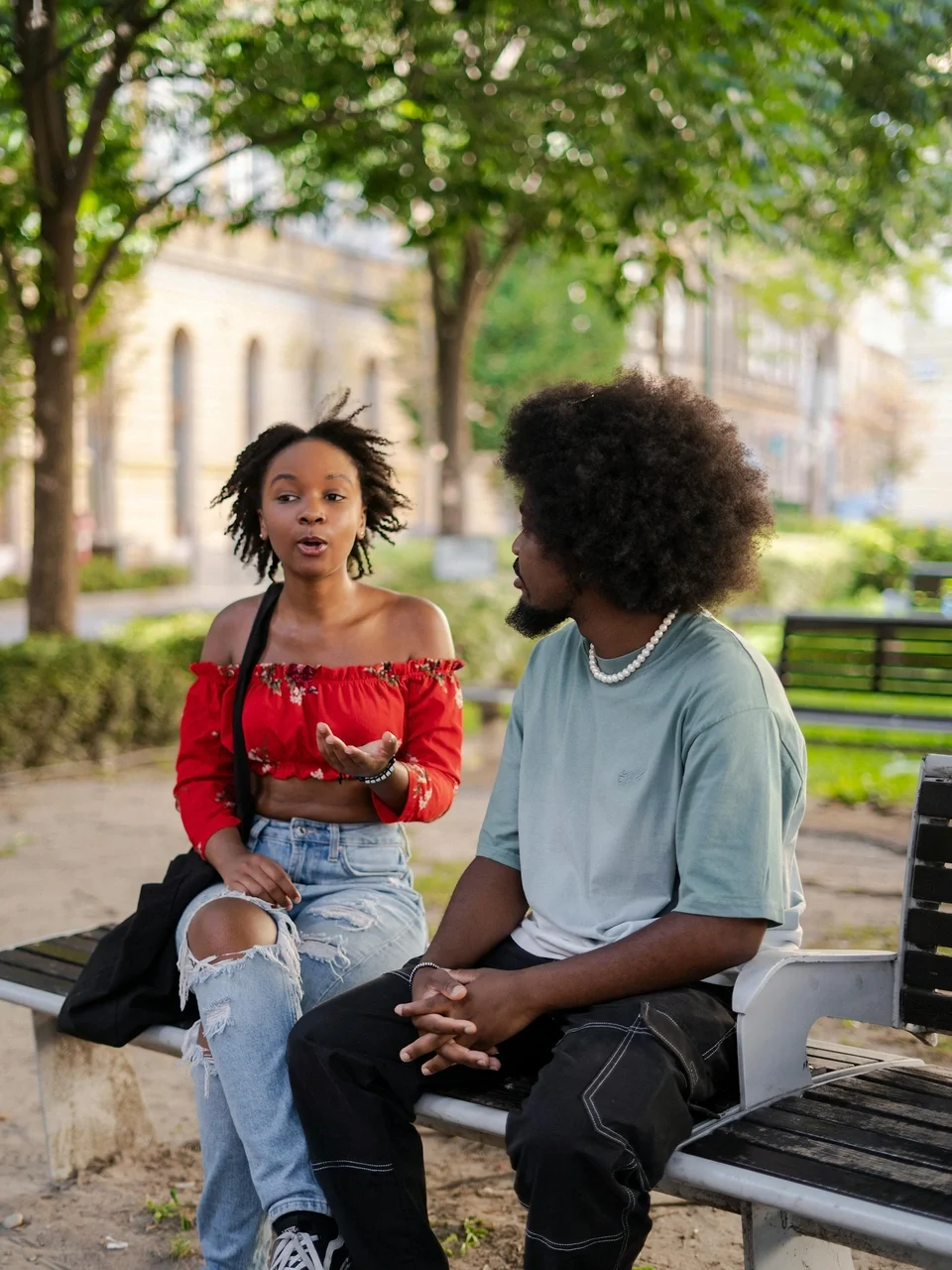 Young couple having a conversation on a park bench