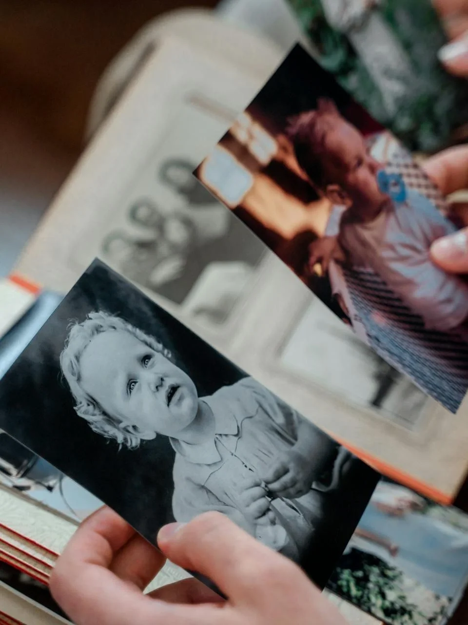 Hands examining nostalgic family photos in an album