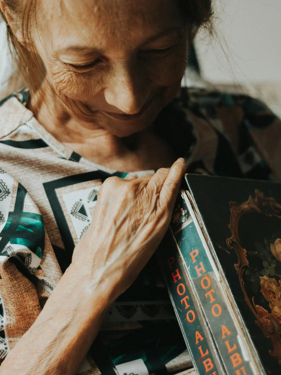 Senior woman reminiscing while holding a cherished photo album