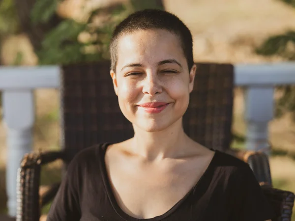 Young woman smiling peacefully outdoors in warm sunlight