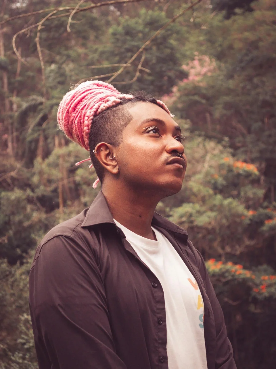Fashionable man with pink dreadlocks in a natural outdoor setting