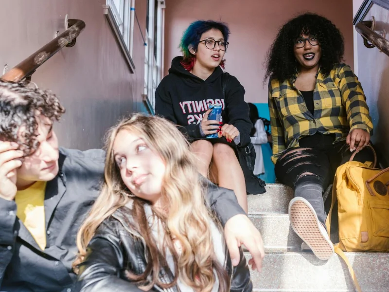 Diverse group of students sitting together on school stairs, enjoying a break